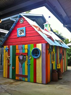 a brightly colored house is on display outside