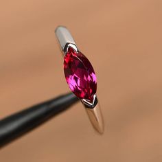 It is a lab ruby ring. The main stone is 5 mm* 10 mm marquise cut.weight about 1.18 carats.The basic metal is sterling silver and plated with rhodium.To change the metal to a solid gold (white/rose) or platinum is also available, please ask for a quotation if you want.You can also go to my shop Home for more elegant rings: https://www.etsy.com/shop/godjewelry?ref=hdr_shop_menu Ruby is July birthstone More ruby rings:https://www.etsy.com/shop/godjewelry?ref=seller-platform-mcnav&section_id=20 Silver Couple Rings, Elegant Rings, Ring Ruby, Ring Marquise, Baguette Diamond Rings, Stacking Ring Set, Round Cut Engagement Rings, Rose Gold Wedding Bands, Ruby Engagement Ring