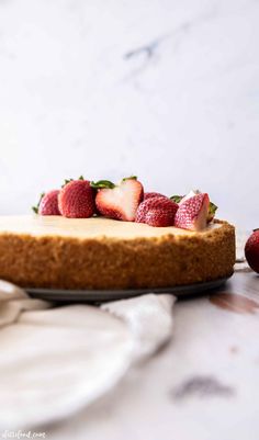 a cheesecake topped with strawberries on top of a table