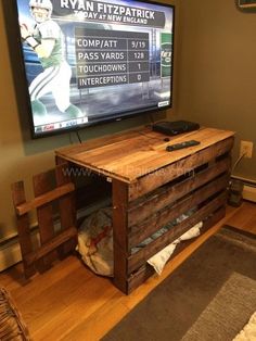 an entertainment center made out of pallets with a tv on the wall behind it