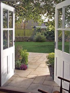 an open door leading to a lush green yard