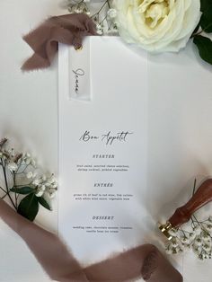 the wedding stationery is laid out on top of the table with flowers and ribbons