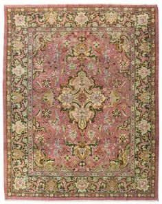 an antique rug with pink and green colors