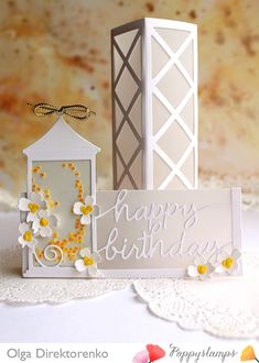 a white card with yellow flowers on it and a candle holder next to it that says happy birthday