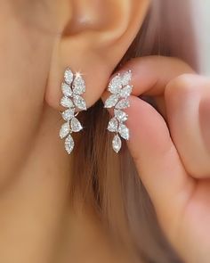 a close up of a person's ear wearing some kind of diamond stud earrings