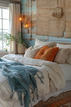 a bed with pillows and blankets on top of it next to a window in a bedroom