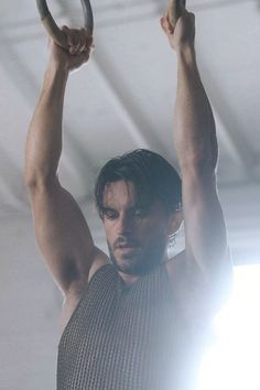 a shirtless man holding a ring above his head