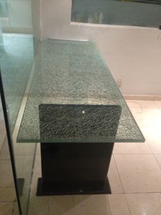 a glass table sitting on top of a tiled floor next to a window in a room