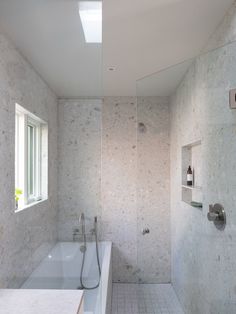 a bathroom with a bathtub, sink and shower head mounted to it's wall