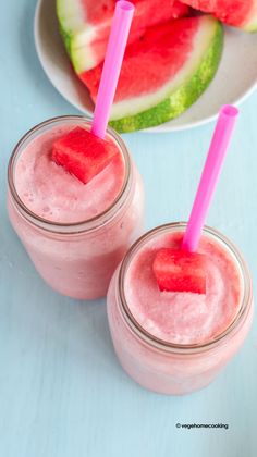 two watermelon smoothies in mason jars with pink straws