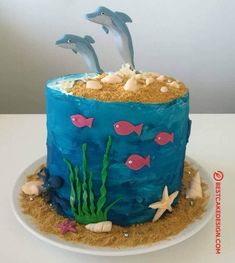 a blue cake with two dolphins on top