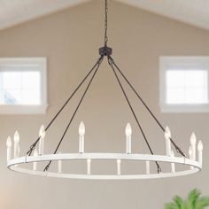 a white chandelier with candles hanging from it's center ring in a living room