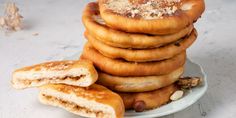 a stack of cookies sitting on top of a white plate next to some walnuts