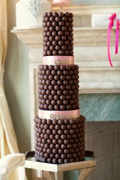 a three tiered cake with chocolate candies on it