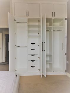 an empty bedroom with white cabinets and drawers