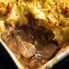 a casserole dish with meat, potatoes and gravy