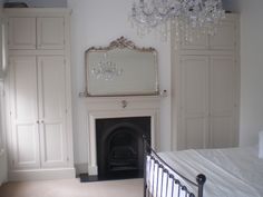 a bedroom with a bed, dressers and a chandelier