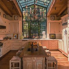 a large kitchen with wooden floors and an arched glass ceiling over the island countertop