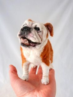 a hand holding a small dog figurine in it's palm