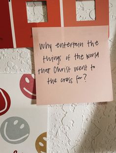 a pink note attached to a wall next to other colorful pieces of paper with words written on them