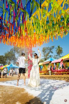 a man and woman walking under colorful streamers