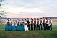 a group of people standing next to each other on top of a grass covered field