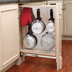 an open cabinet with pots and pans in it