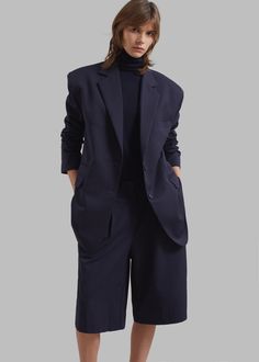 Color: Navy Midweight traditional suiting fabric Boxy fit Notch lapels Padded shoulders Illusion welt breast pocket Front flap pockets Button cuffs Side slits Front button closure Lined 65% Polyester 35% Rayon Dry Clean By The Frankie Shop. Imported Tailored Solid Color Pantsuit With Pockets, Professional Blazer With Pockets, Tailored Business Casual Pantsuit With Pockets, Lapel Collar Pantsuit With Pockets For Work, Notch Lapel Pantsuit With Pockets For Office, Tailored Workwear Blazer With Button Cuffs, Tailored Blazer With Button Cuffs For Work, Tailored Fall Pantsuit With Welt Pockets, Workwear Pantsuit With Pockets And Suit Collar