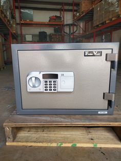 an electronic security box sitting on top of a wooden pallet in a storage area