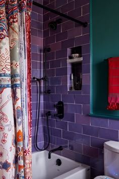 a bathroom with purple and blue tiles on the walls, toilet and bathtub in it