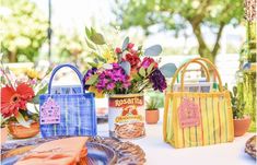 there are many bags on the table with flowers and other things around it that is decorated