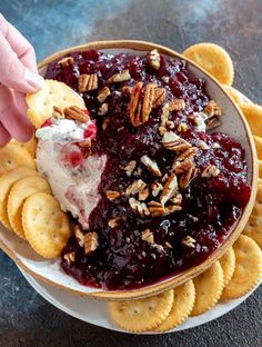 a bowl filled with fruit and crackers sitting on top of a plate next to some crackers