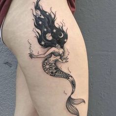 a woman's thigh with a mermaid tattoo on it