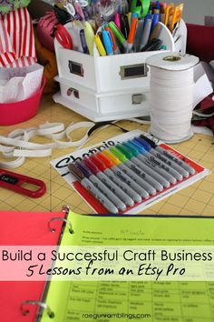 a bunch of craft supplies sitting on top of a table next to a binder