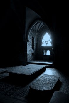 a dark room with two benches and a stained glass window