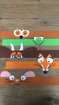 three strips of paper cut out to look like cats and dogs with faces on them