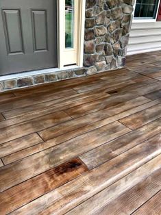 the front porch with wood flooring and stone wall