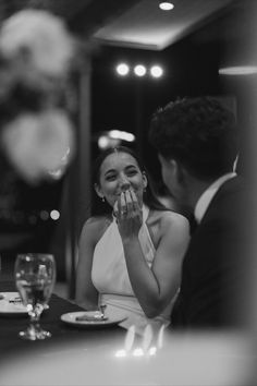 a woman sitting at a table in front of a man