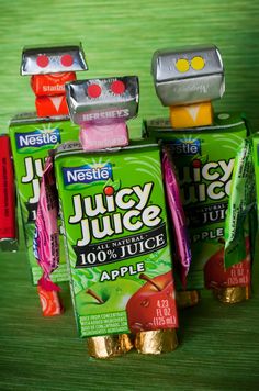 three packages of juice sitting next to each other on top of a green tablecloth