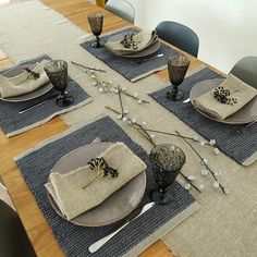 the table is set with place mats and place settings for four people to sit at