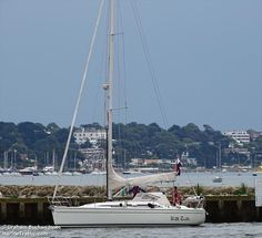 a sailboat in the water next to a dock