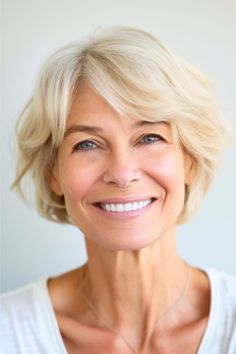 Layered Short Cut With Side Swept Bangs Hairstyle on smiling older woman with blonde hair. Highlighted Bangs, Layered Bob With Bangs, Wavy Pixie, Short Afro, Side Swept Bangs, Voluminous Hair, Short Waves, Haircut For Older Women, Blonde Pixie