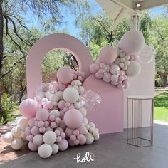 balloons are floating in the air near a pink wall