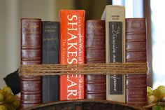 a stack of books with twine on top of each other in front of some grapes