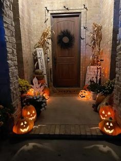 pumpkins are lit up in front of the door to a home decorated for halloween