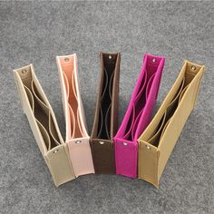 five different colored paper bags sitting on top of a carpeted floor next to each other