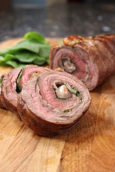 sliced ham on a cutting board with spinach leaves