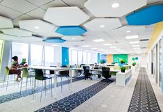 an empty office with blue, yellow and white decor on the ceiling is pictured in this image