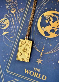 Our handmade Tarot Card World necklace is a unique piece perfect for free-spirited wanderers seeking inspiration as it exudes a sense of mystique and adventure. Wear it as a reminder to explore and embrace the limitless possibilities of life, and be sure to capture the attention of anyone who lays eyes on it. Ideal for tarot enthusiasts or anyone seeking a touch of cosmic energy in their life. You can make the necklace even more special by adding a personalization on the back of the pendant with Cosmic Necklace, The World Tarot, Tarot Gifts, Spiritual Travel, World Map Necklace, World Necklace, Map Jewelry, Wanderlust Jewelry, Meaningful Necklace