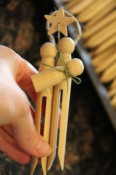 a person holding some wooden pegs with stars on them in front of pasta noodles